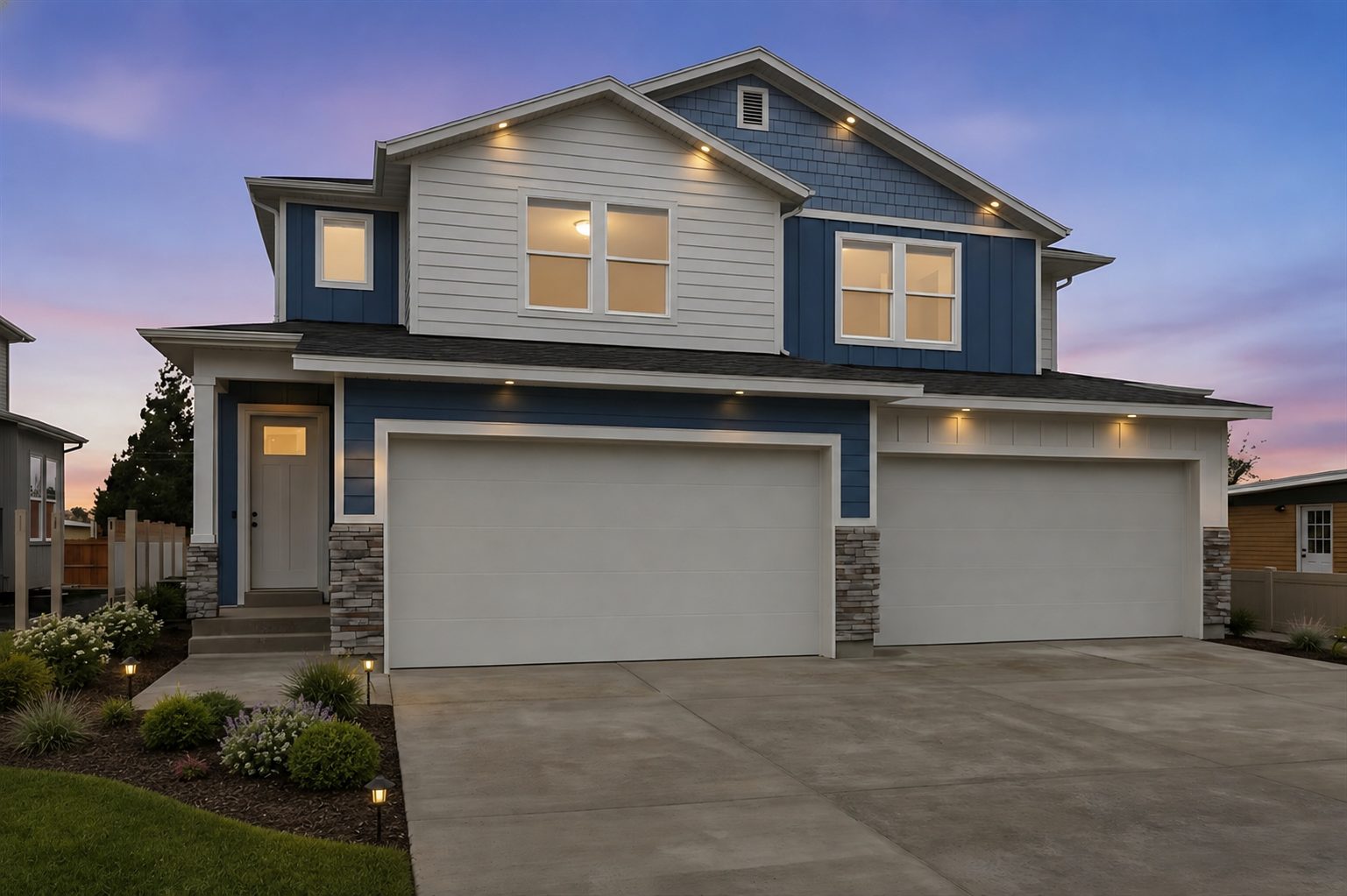 Twin homes at twilight with landscaped yard